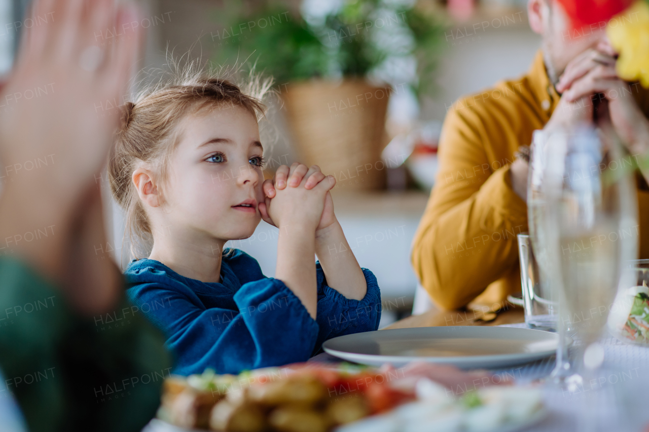 Close-up of family praying before Easter dinner.