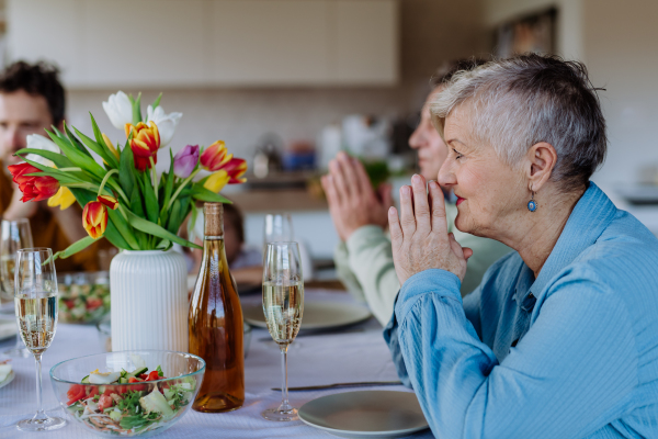 Close-up of family praying before Easter dinner.