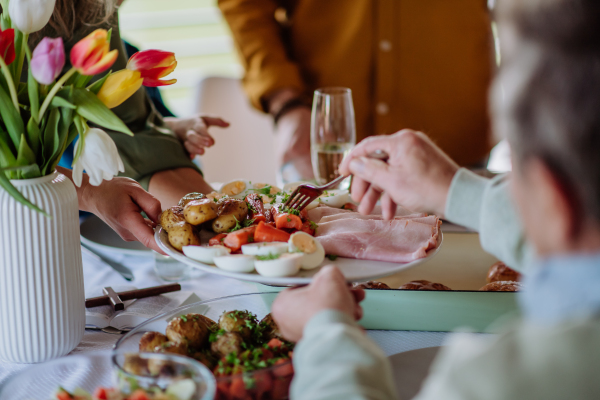 Close up of muligenerational family serving Easter lunch together.