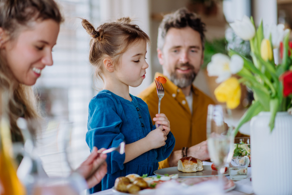 Happy young family having Easter lunch together.