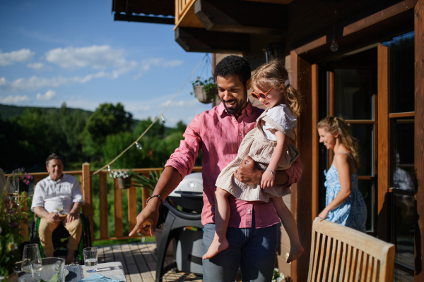 Multi generation family having party outside in the backyard on a patio.