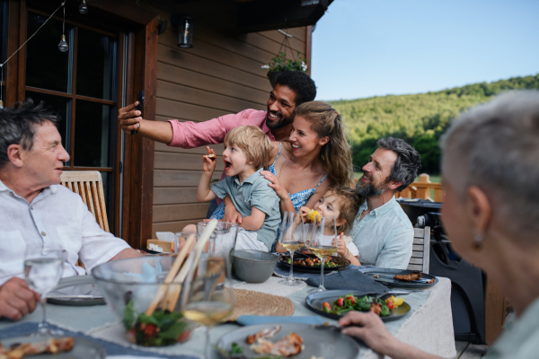 Multigenerational family having bbq party and taking a selfie.