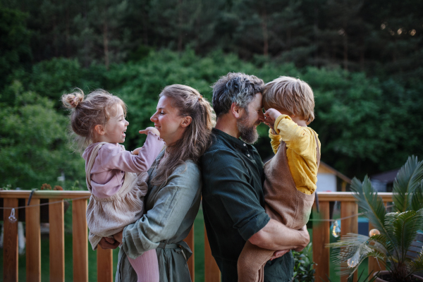 Parents holding their children, enjoying together time outdoor at their terrace.