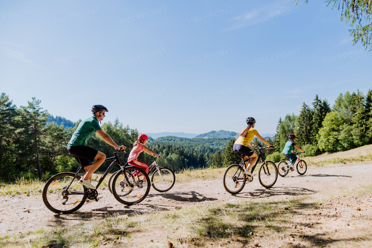 Young family with little children at a bike trip together in nature.