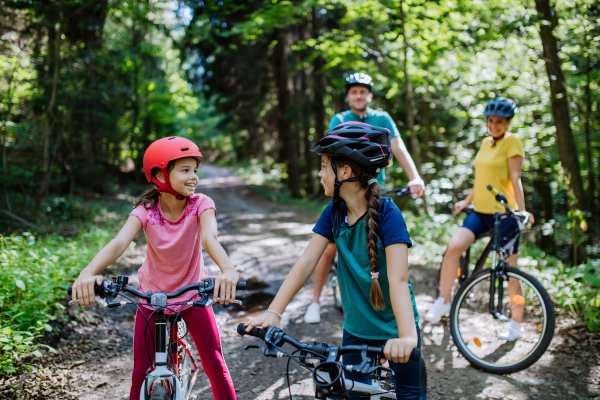 Young family with little children at a bike trip together in nature.