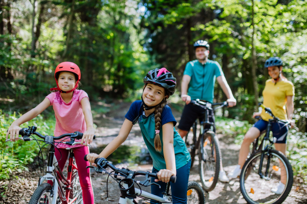 Young family with little children at a bike trip together in nature.