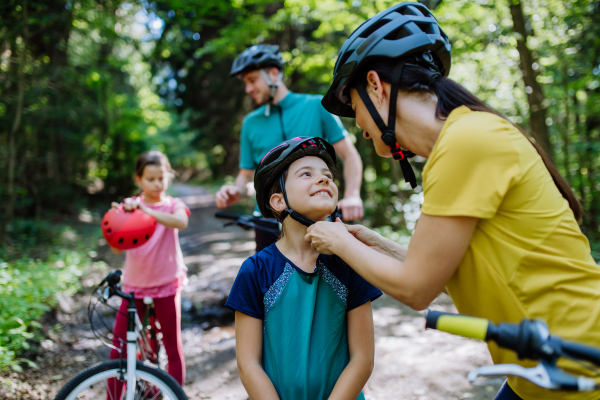 Young family with little children at a bike trip together in nature.