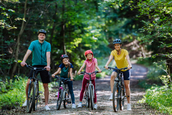 Young family with little children at a bike trip together in nature.