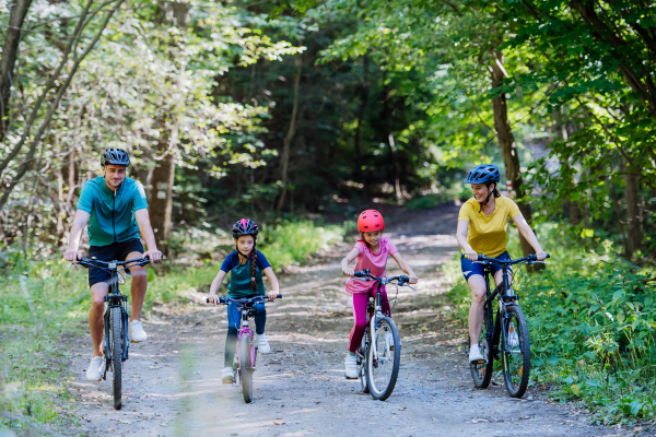 Young family with little children at a bike trip together in nature.