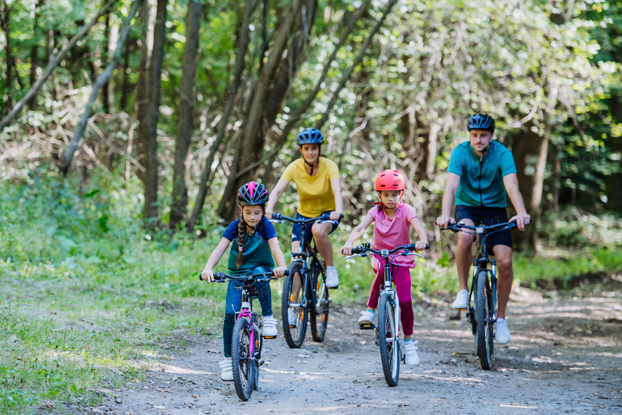 Young family with little children at a bike trip together in nature.