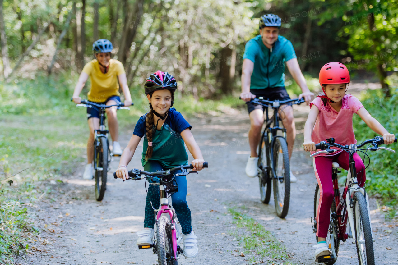 Young family with little children at a bike trip together in nature.