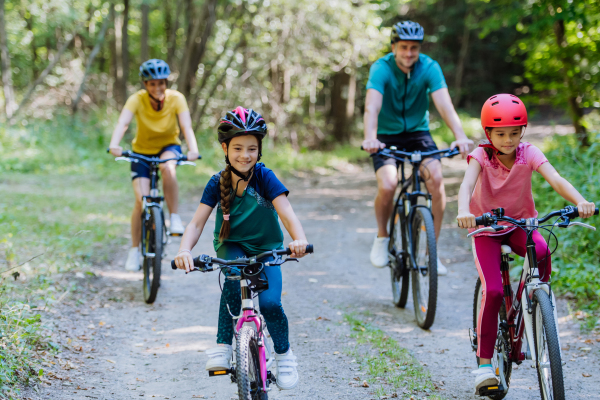 Young family with little children at a bike trip together in nature.