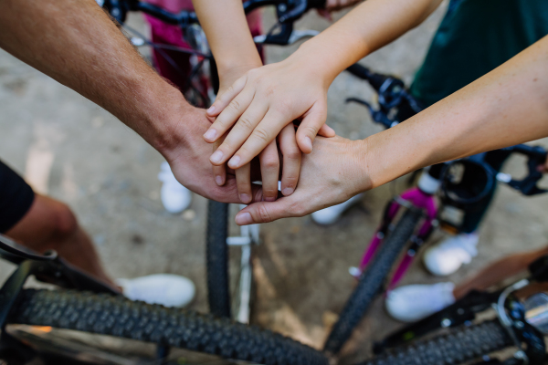 Top view of family holding hands together during a bicycle trip, concept of cooperation.