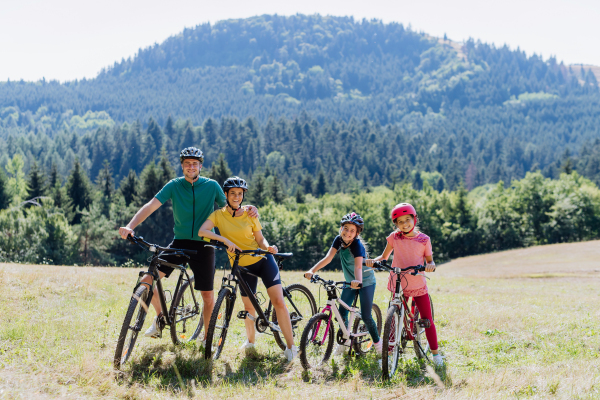 Young family with children at bike trip,posing with bicycles in the nature.