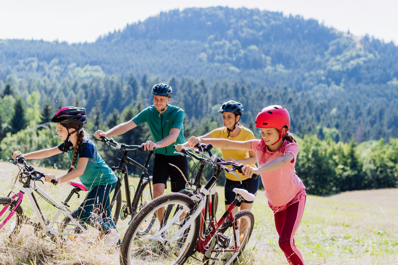 Young family with little children at a bike trip together in nature.