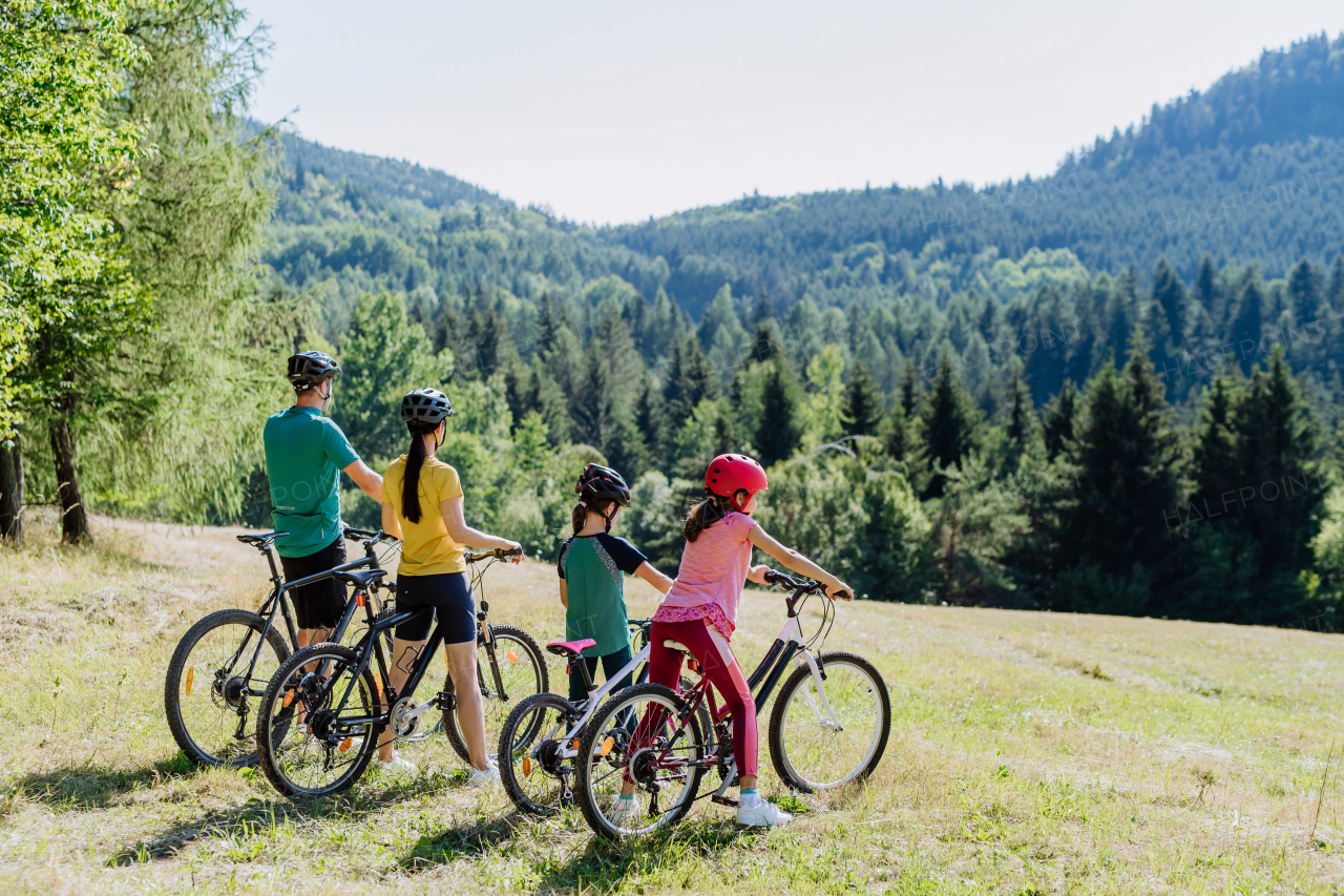 Young family with little children at a bike trip together in nature.