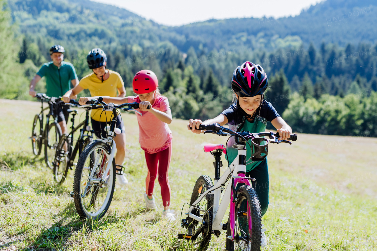 Young family with little children at a bike trip together in nature.