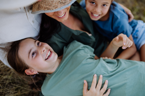 Happy, affectionate mother and daughters hugging during sunset.