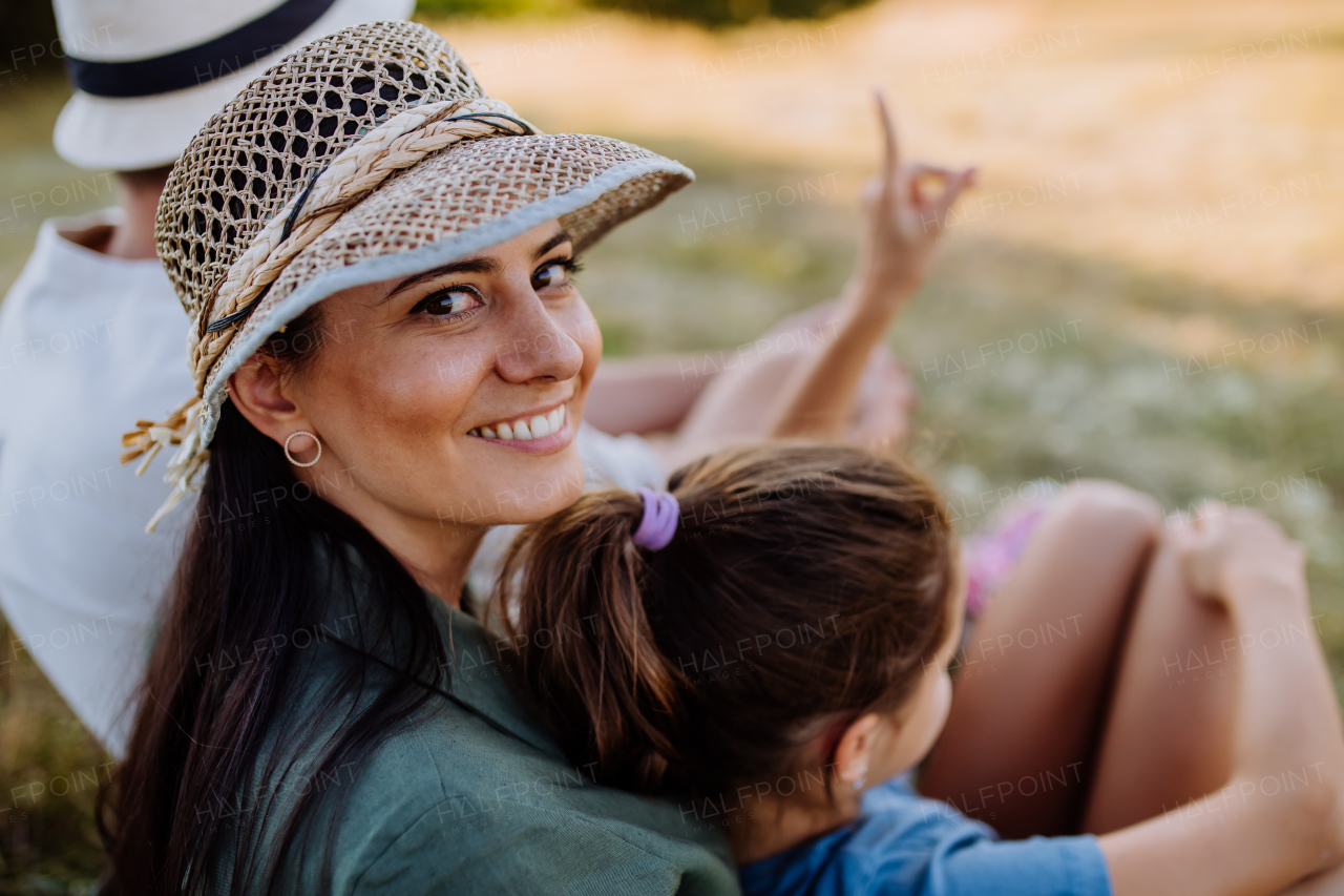 Happy, affectionate mother and daughter hugging during sunset.