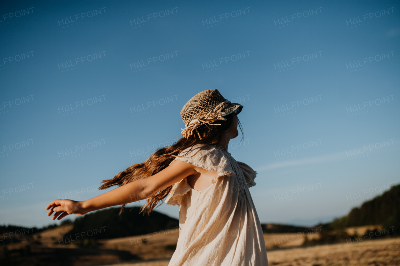 A portrait of a beautiful little girl feeling free in summer in nature.