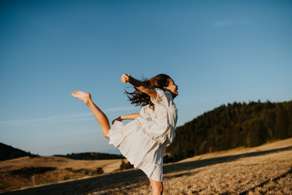 A portrait of a beautiful little girl feeling free in summer in nature.