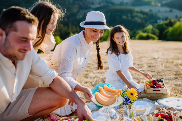 Happy family with children having picnic in the park.