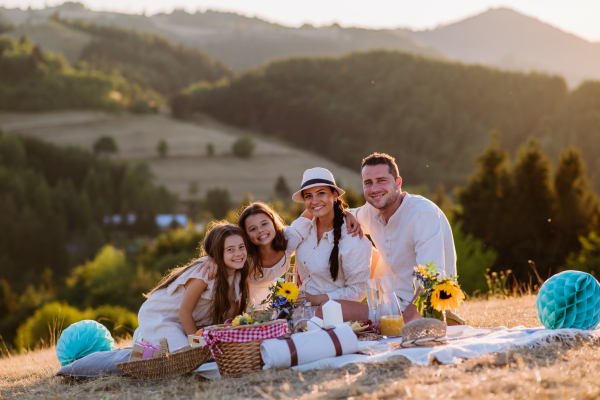 Happy family with children having picnic in the nature.