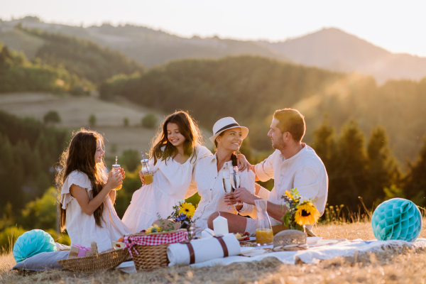 Happy family with children having picnic in the nature.