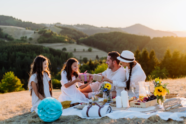 Happy family with children having picnic in nature,celebratig, giving each other gifts.