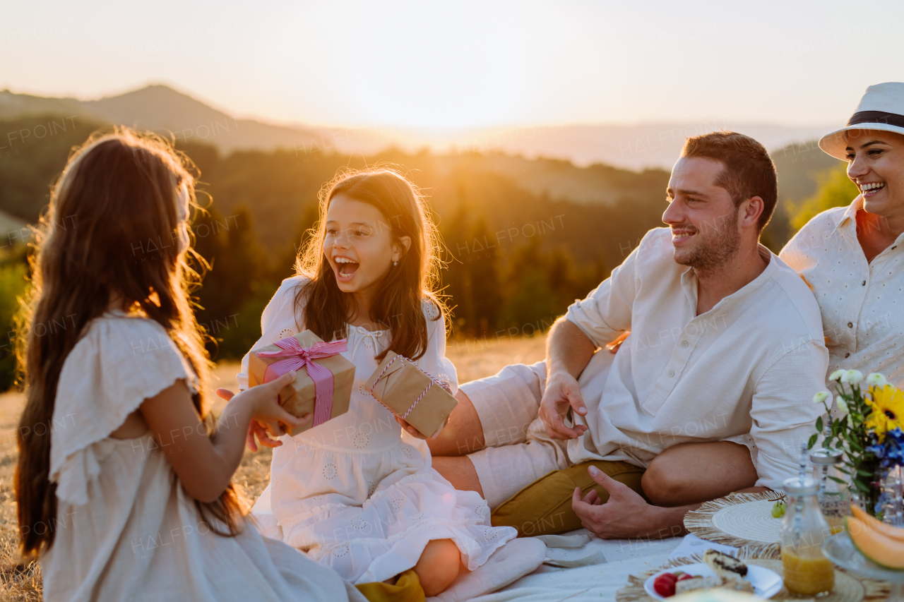 Happy family with children having picnic in nature,celebratig, giving each other gifts.