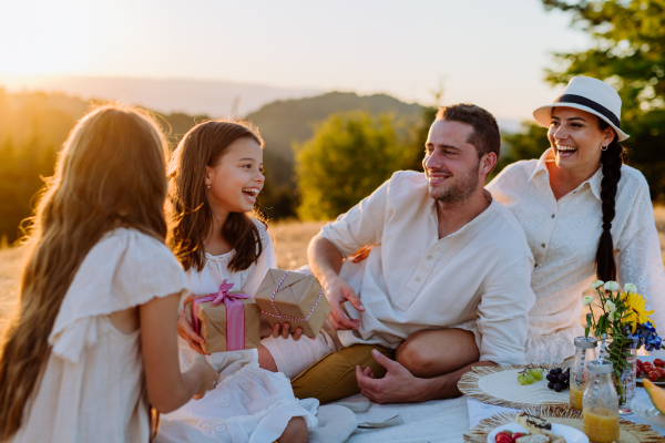 Happy family with children having picnic in nature,celebratig, giving each other gifts.