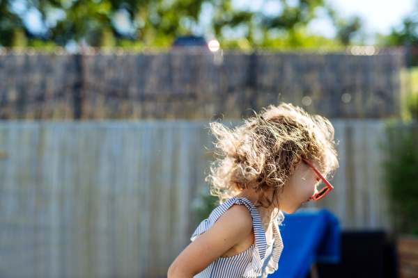 A happy kid having fun when running round the swimming pool with. Summer outdoor water activity for kids.