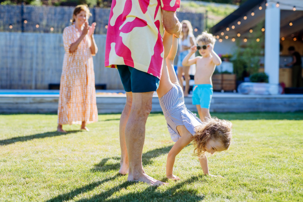 Grandfather with his granddaughter having fun at the family garden party.