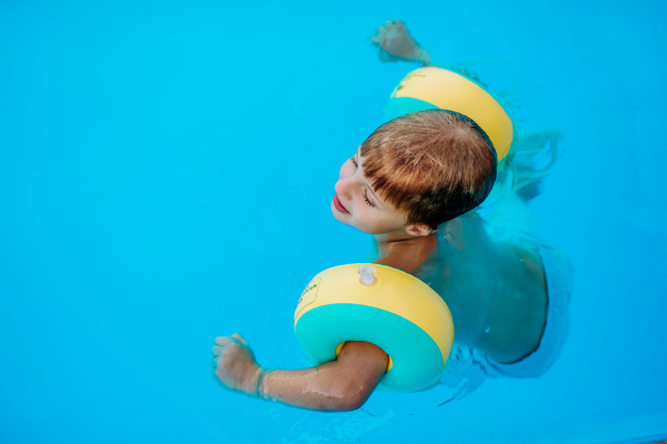 Little boy enjoying summer in the pool.