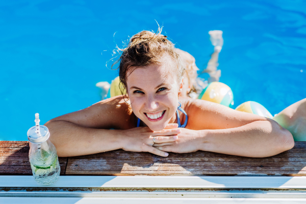 Young woman enjoying summer time in an outdoor pool.