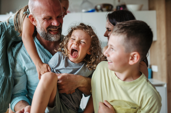 Cheerful family with three kids laughing and having fun together. Concept of family bonding.