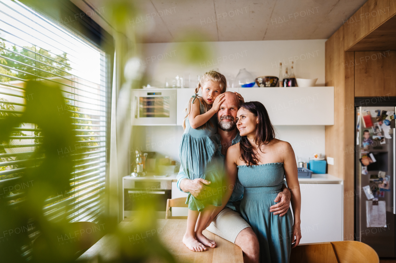 Cheerful family with one kid having fun together in kitchen. Concept of family bonding.