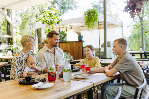 Big family with children and a small baby at family dinner in a restaurant. A small family celebration in family friendly restaurant.