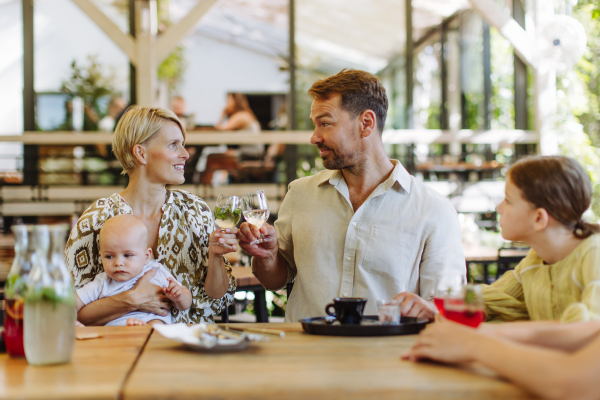 Big family with children and a small baby at family dinner in a restaurant. A small family celebration in family friendly restaurant.