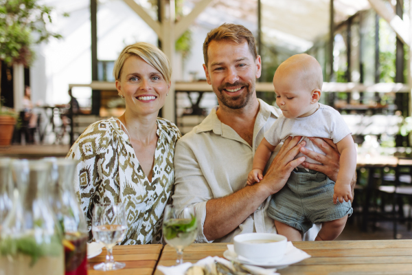 Family with hungry baby eating food, soup at restaurant. Family dinner at a restaurant.