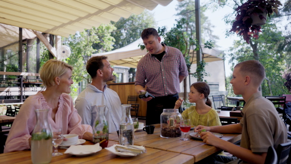 Man paying for lunch in a restaurant, paying by card. Holding card near terminal card reader.