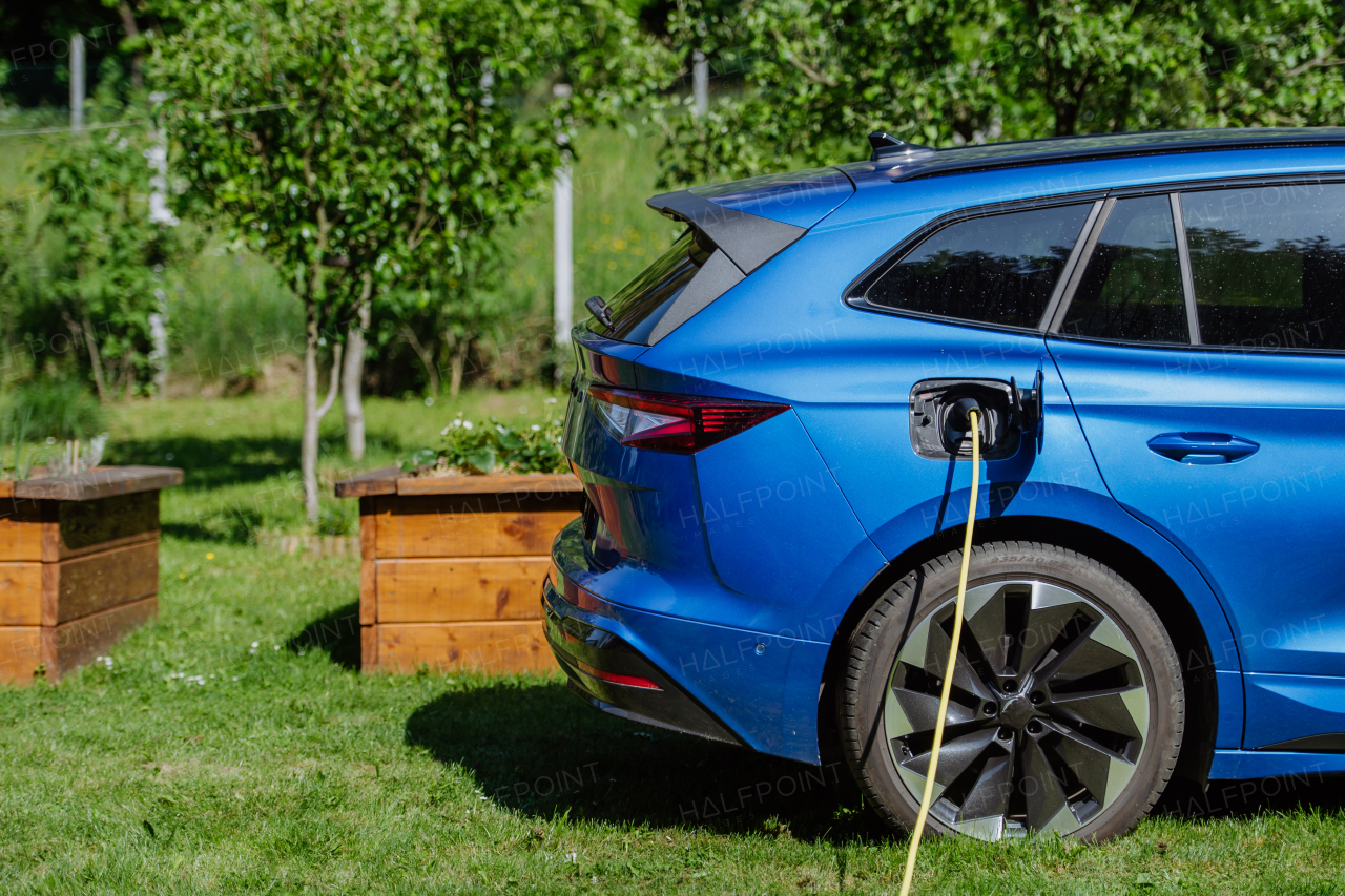 Close up of electric car chaging in family garden.