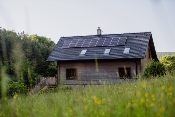 Family house with a solar panels on the roof at meadow.