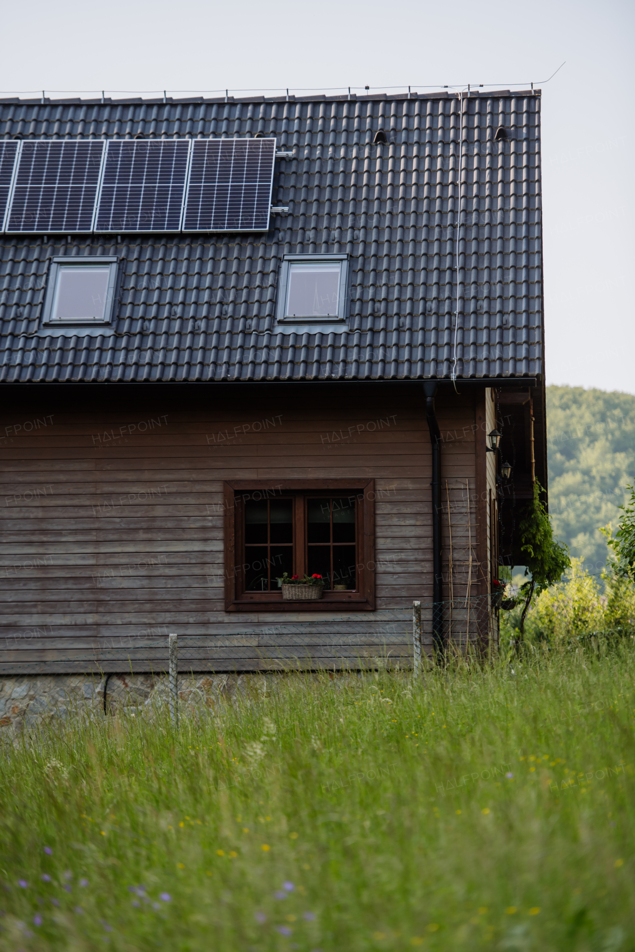 Family house with a solar panels on the roof at meadow.