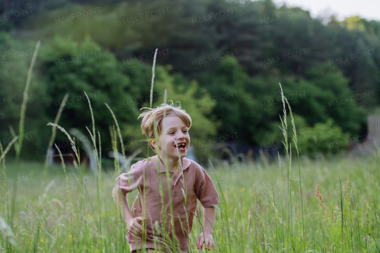 Happy boy playing and running on the meadow.