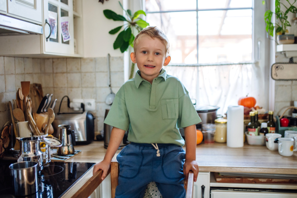 Boy helping with breakfast in home kitchen in the morning.Spending time together before going to school and to work.