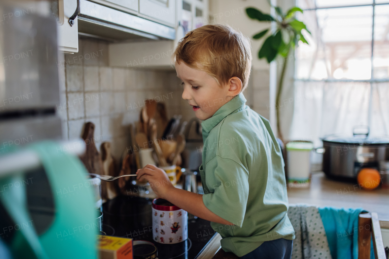 Boy helping with breakfast in home kitchen in the morning.Spending time together before going to school and to work.