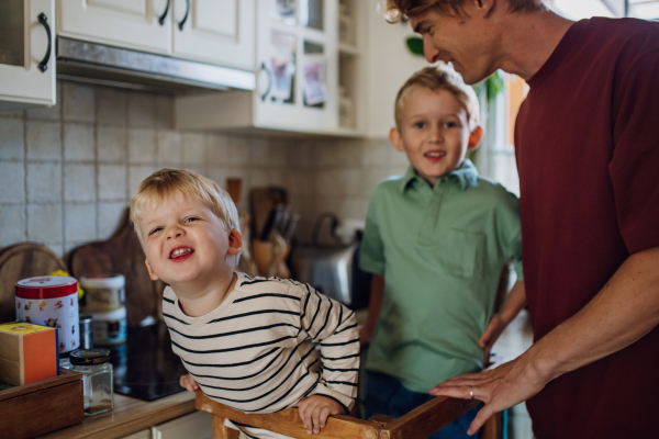 Family preparing breakfast in home kitchen in the morning. Spending time together before going to school and to work.