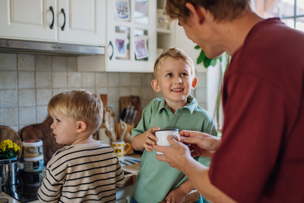 Family preparing breakfast in home kitchen in the morning. Spending time together before going to school and to work.