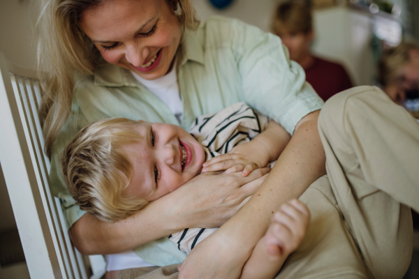 Mother embracing her young son in the kitchen, having bonding moment. Concept of Mother's Day, and motherly love.